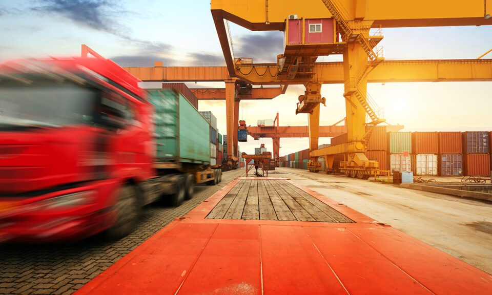 Bild på en containerterminal med lastbil och lastkranar