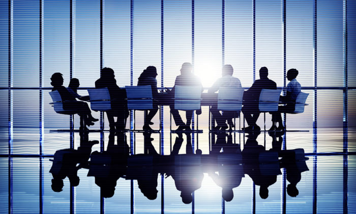 Bild på människor bakifrån som sitter runt ett bord