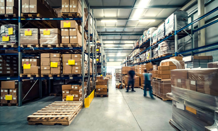 Bild på ett lager med två suddiga människor som arbetar