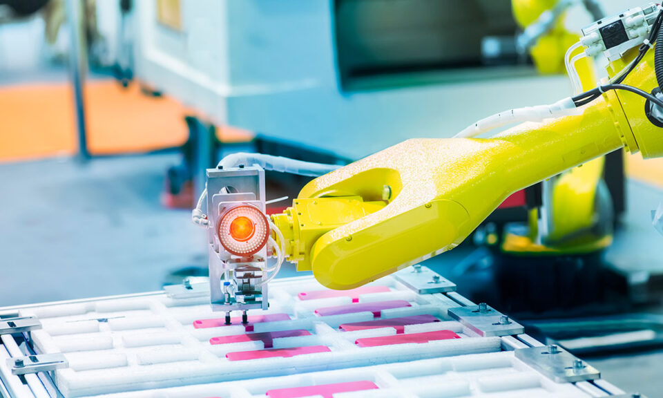 Industriell robotarm som arbetar vid ett automatiserat produktionsband