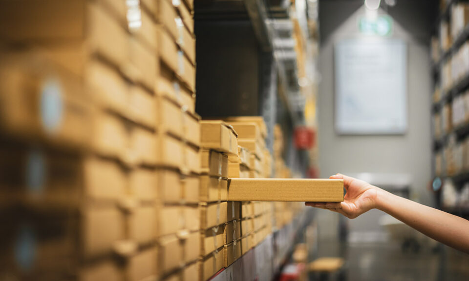 Bild på plockning av kartongförpackning i lagerhylla