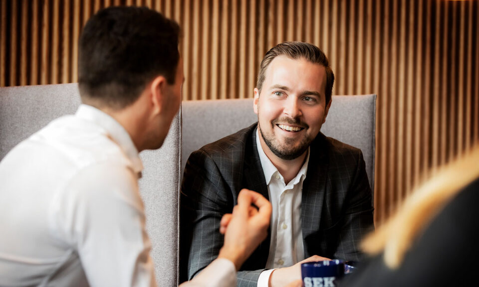 Bild på två män som har en konversation på jobbet