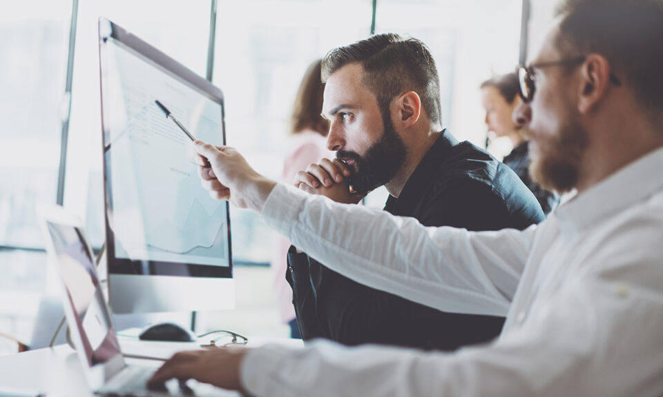 Två män som arbetar och tittar på en datorskärm