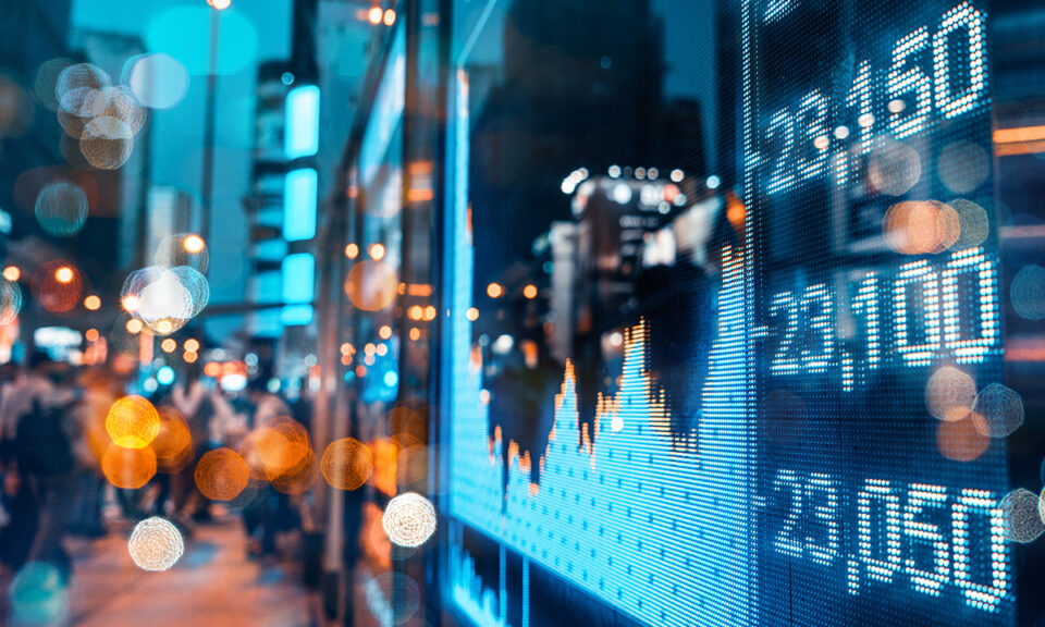 Bilden visar siffror och grafer och en stad i oskärpa i bakgrunden.